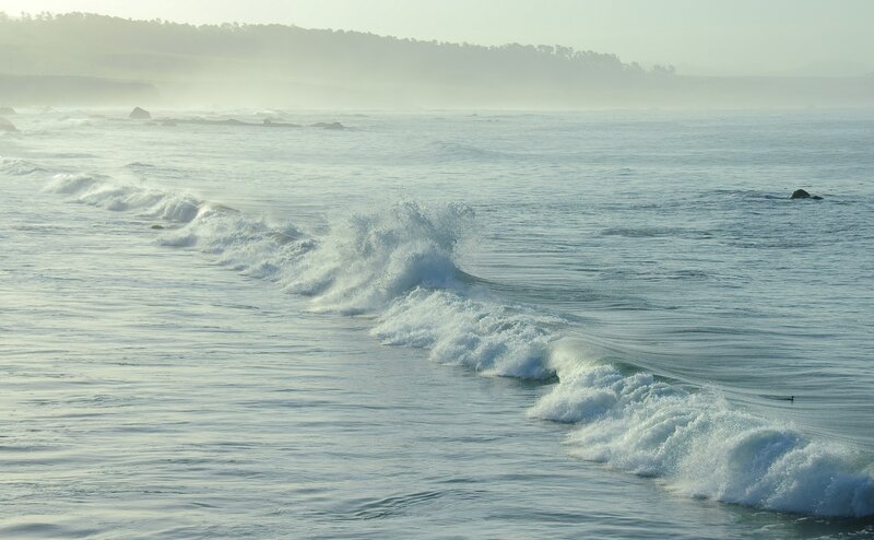 Waves crashing on a misty coast