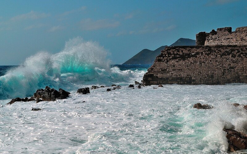 Waves crashing on ancient wall