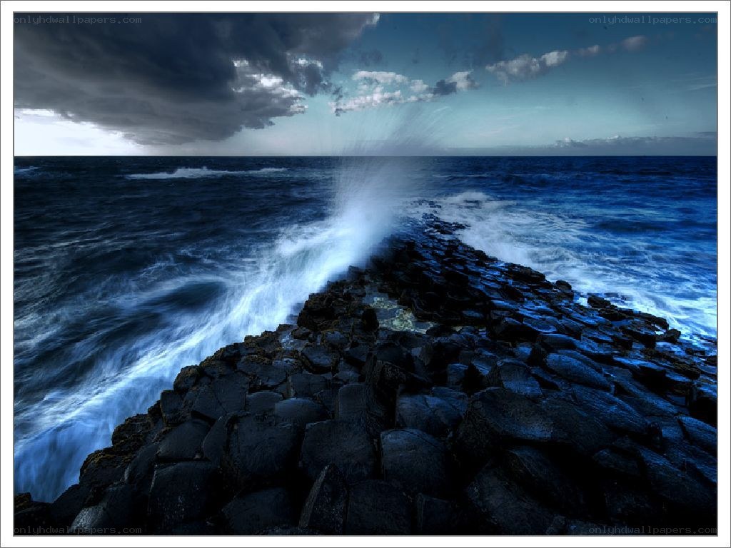 Waves crashing on basalt rocks