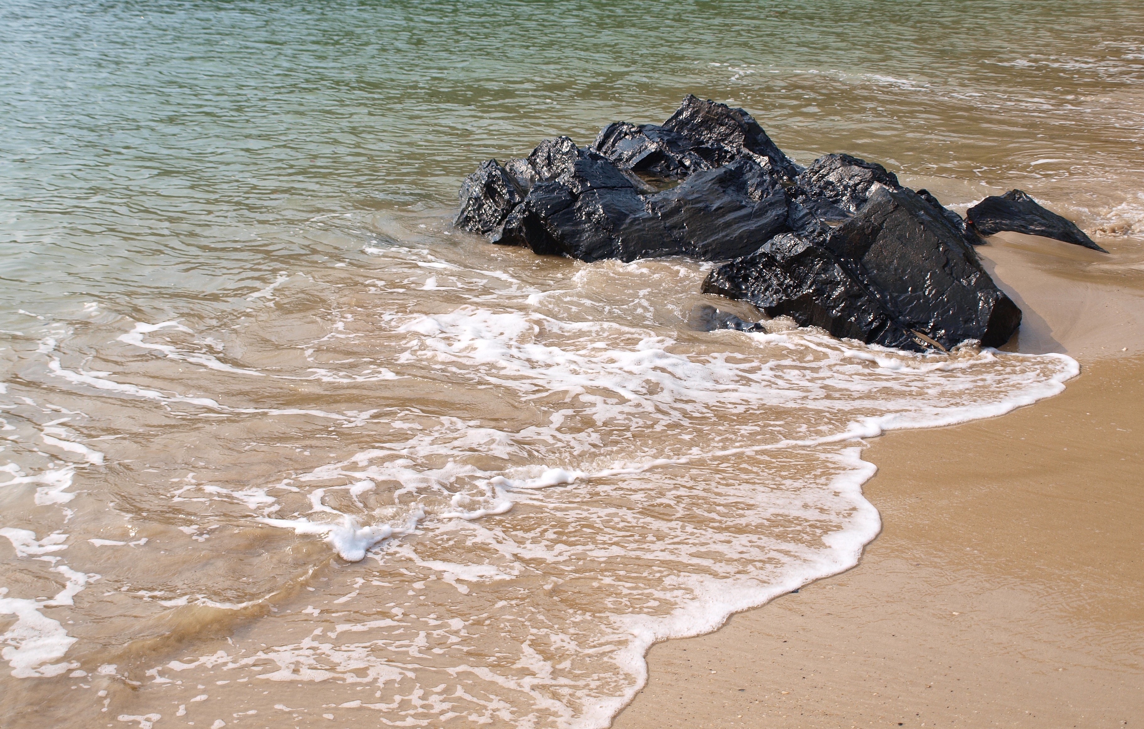 Waves crashing on black rocks