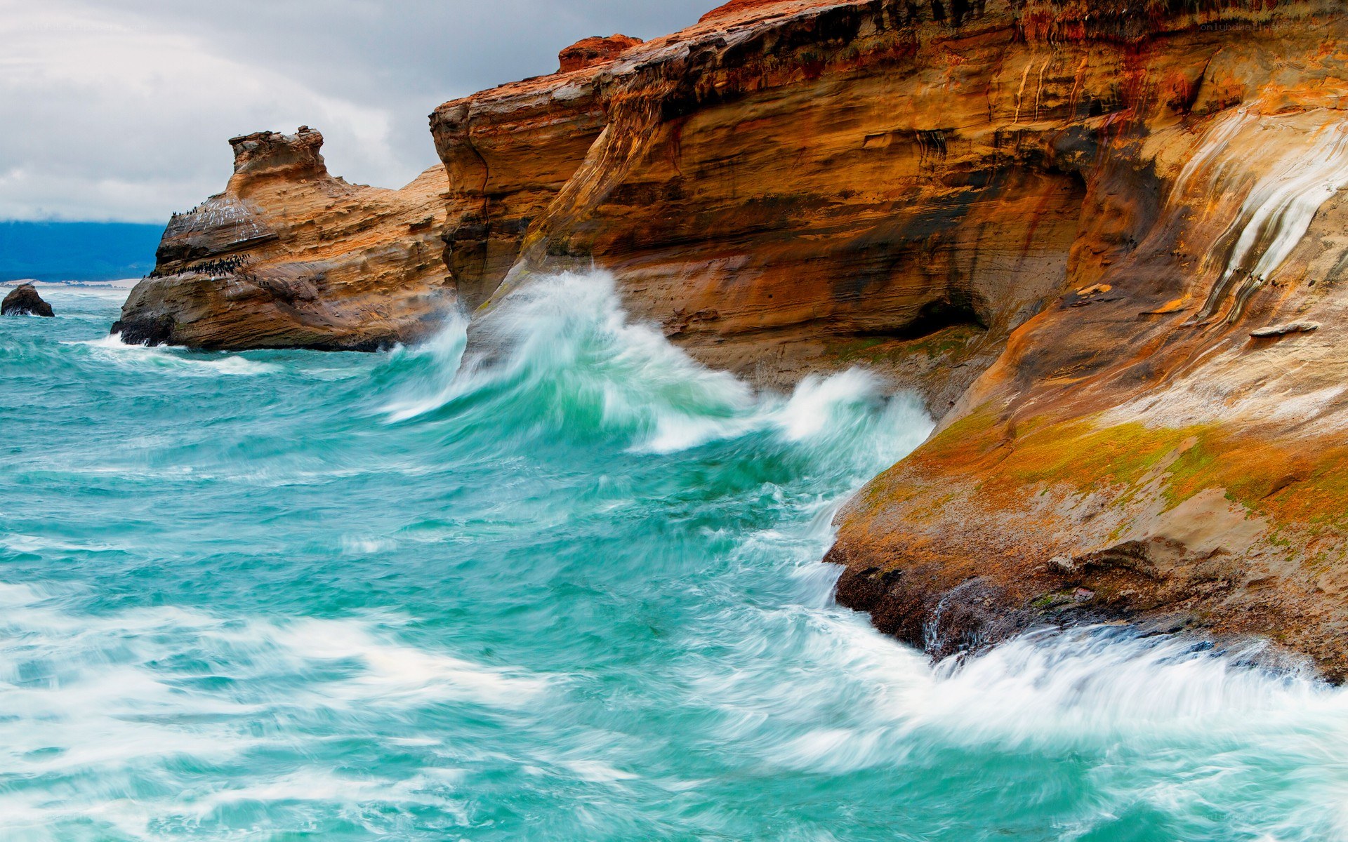 Waves crashing on colorful cliffs