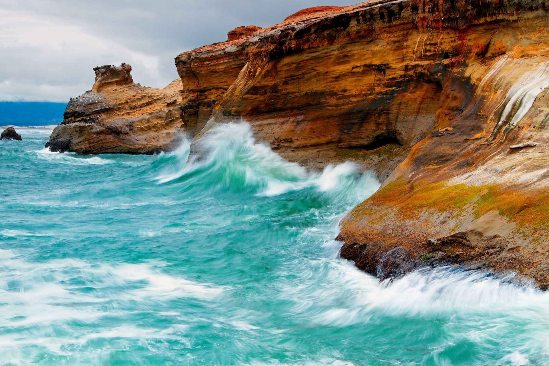 Waves crashing on colorful cliffs