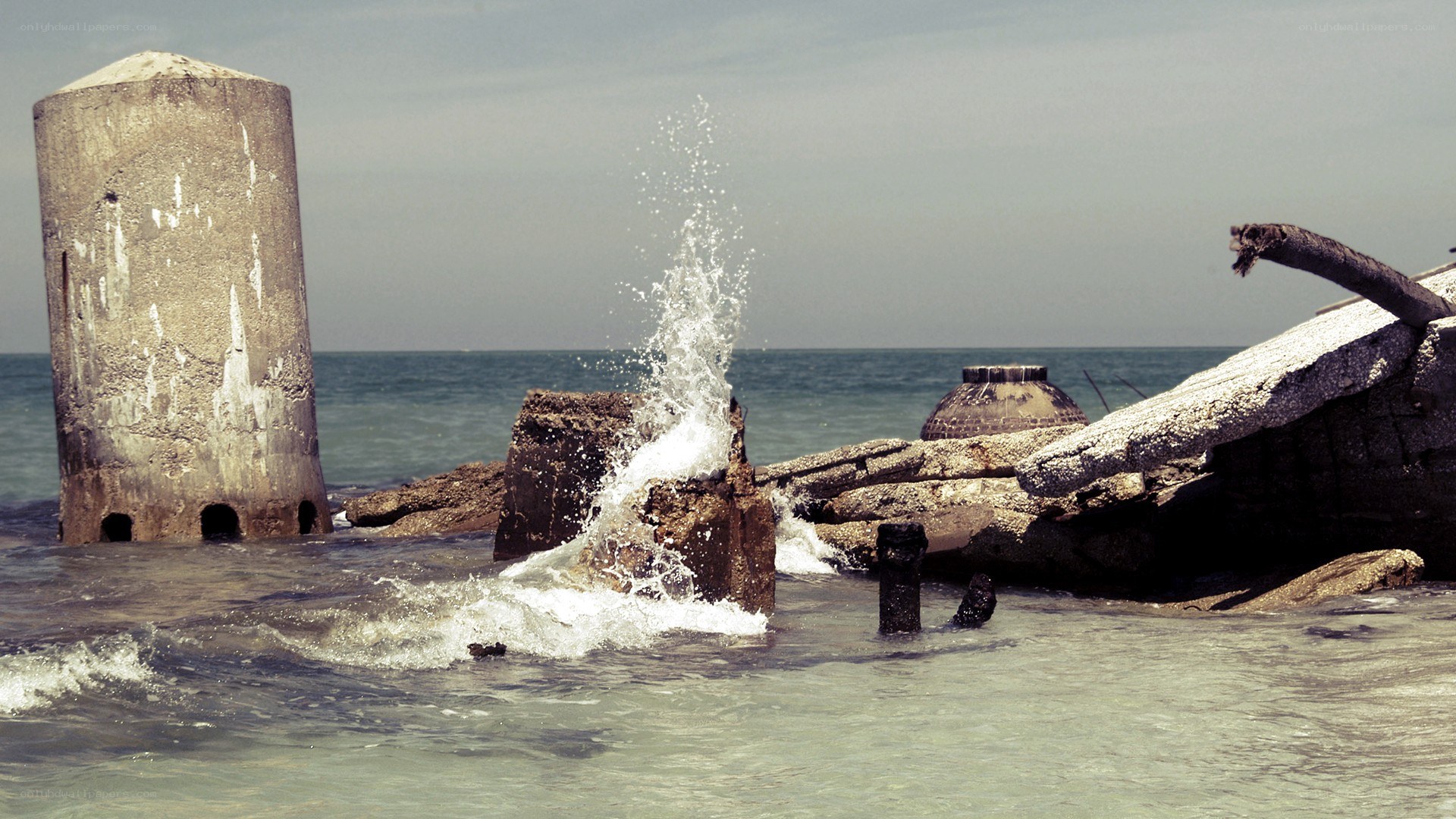 Waves crashing on concrete ruins