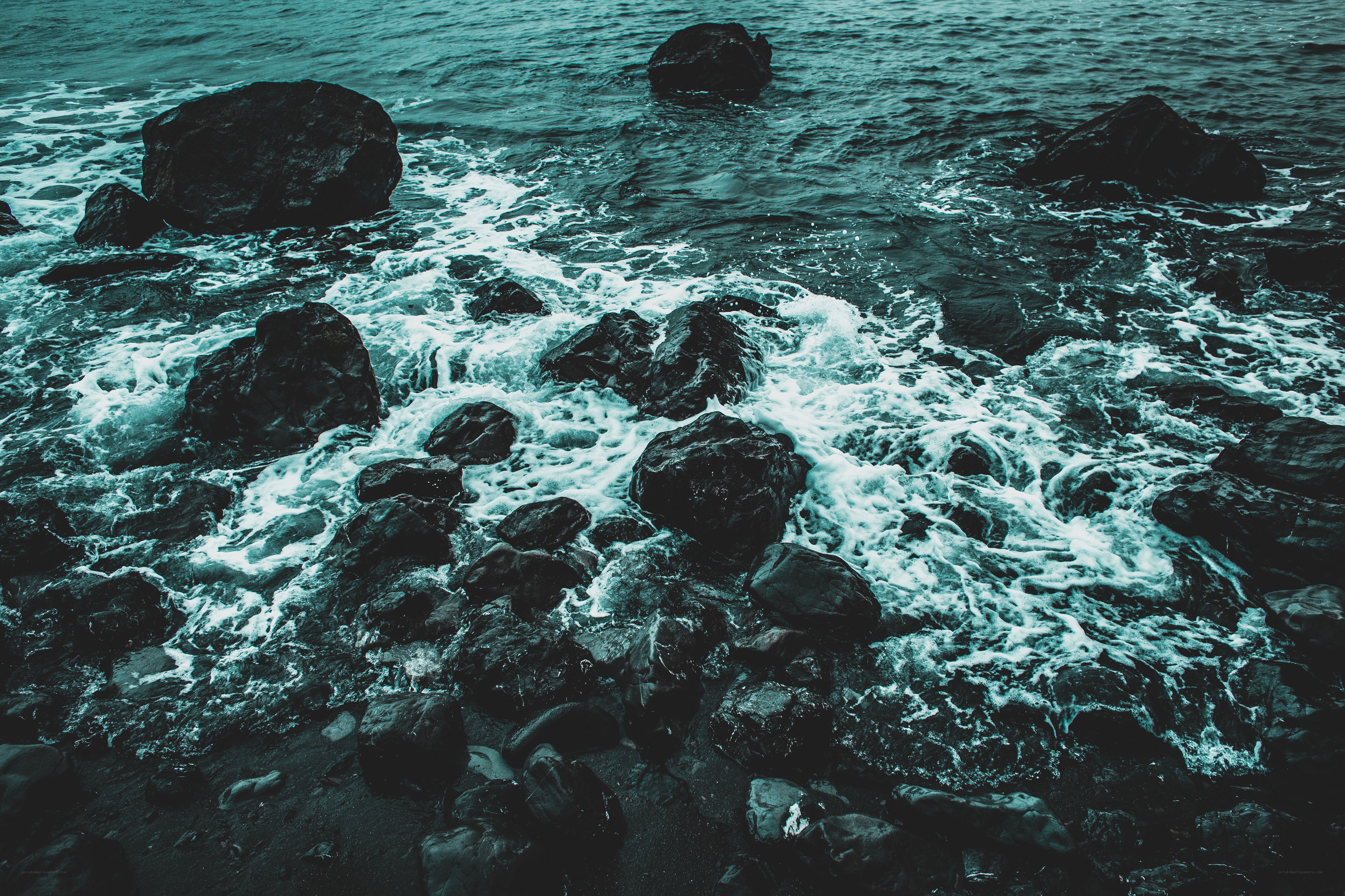 Waves crashing on dark rocks
