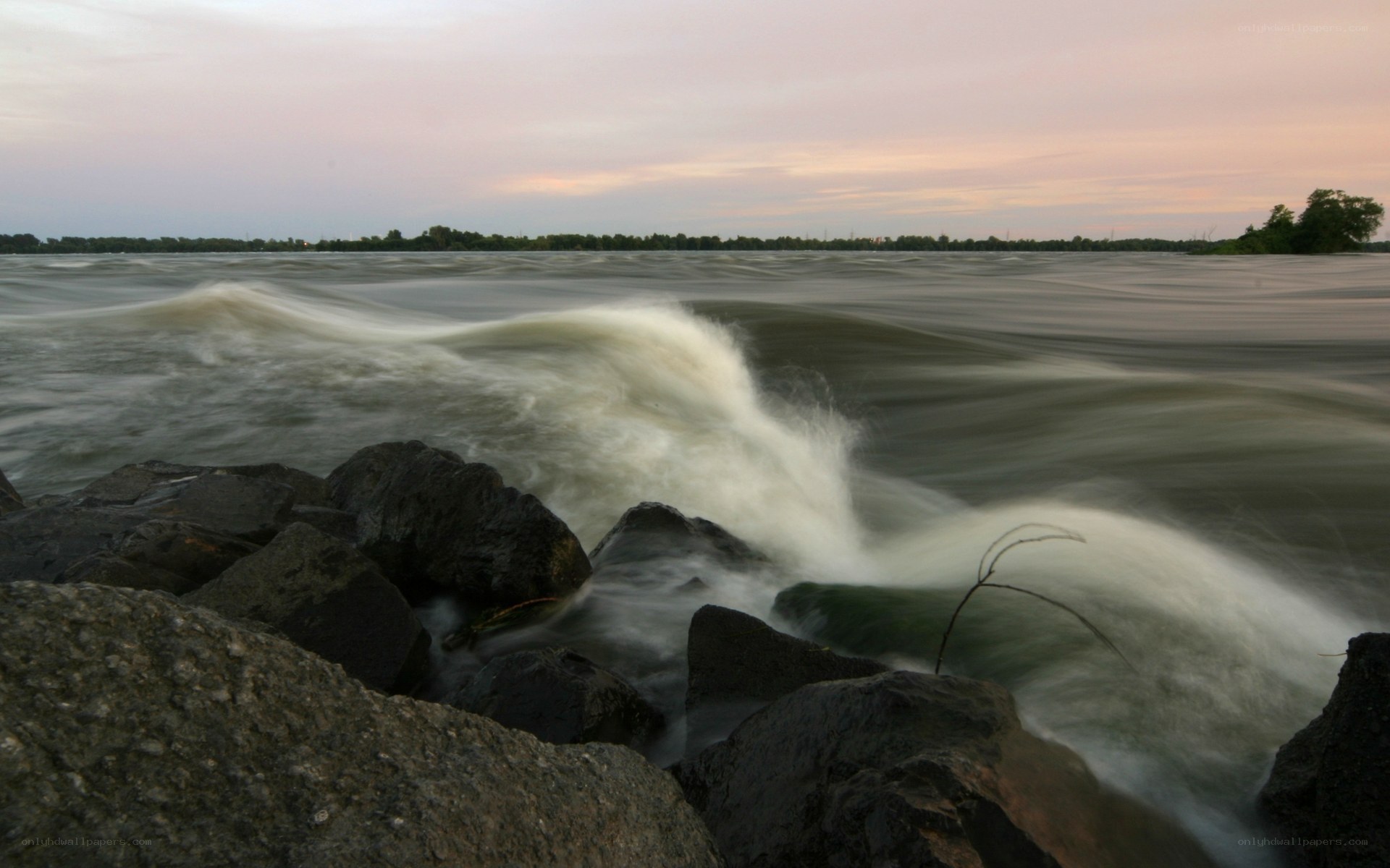 Waves crashing on rocks at dusk