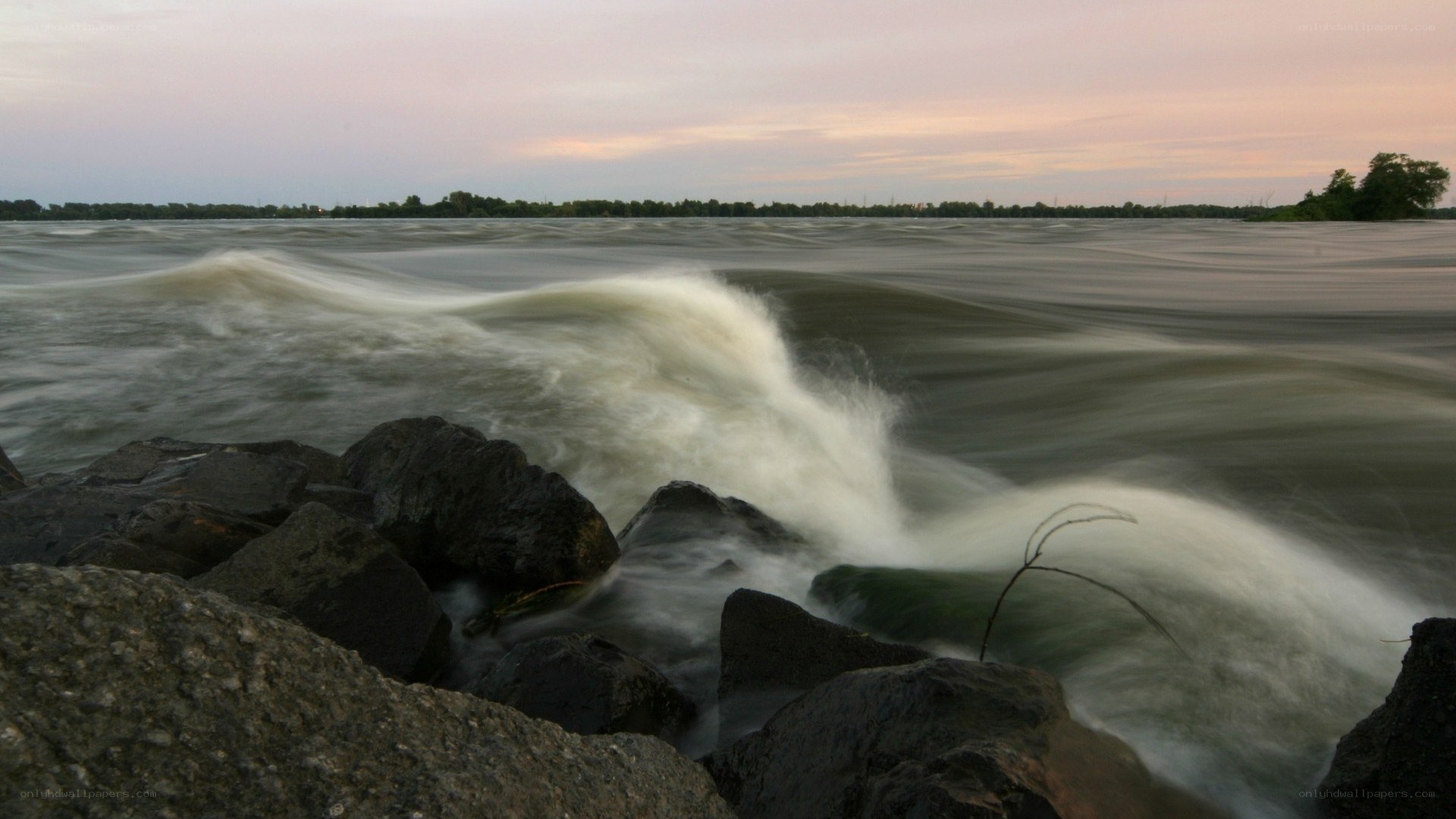 Waves crashing on rocks at dusk