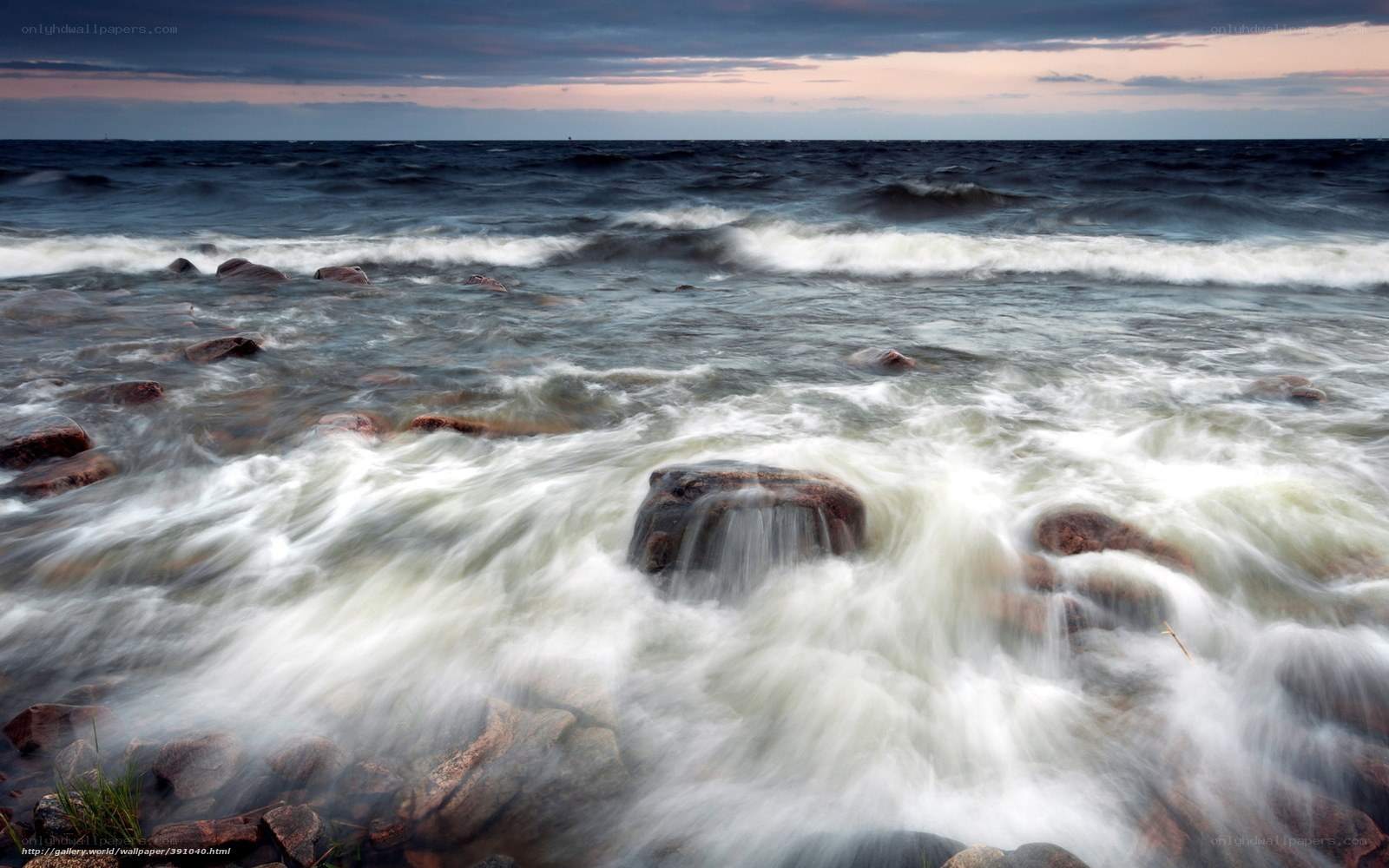 Waves crashing on rocks at dusk
