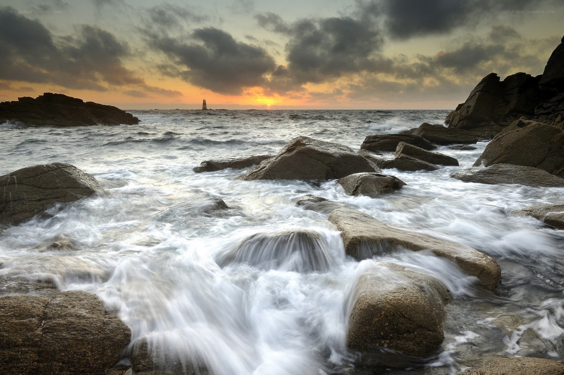 Waves crashing on rocks at sunset