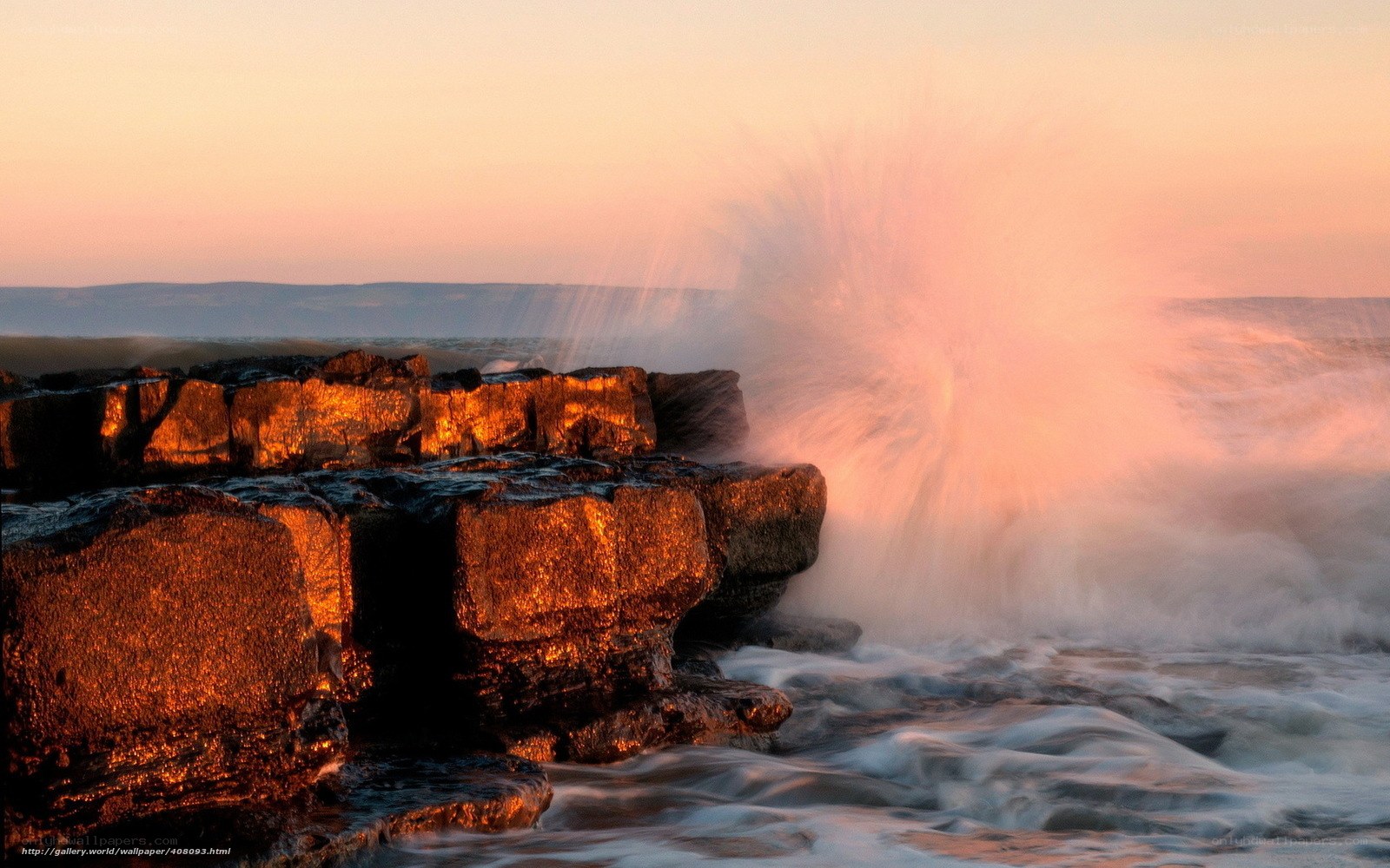 Waves crashing on rocks at sunset