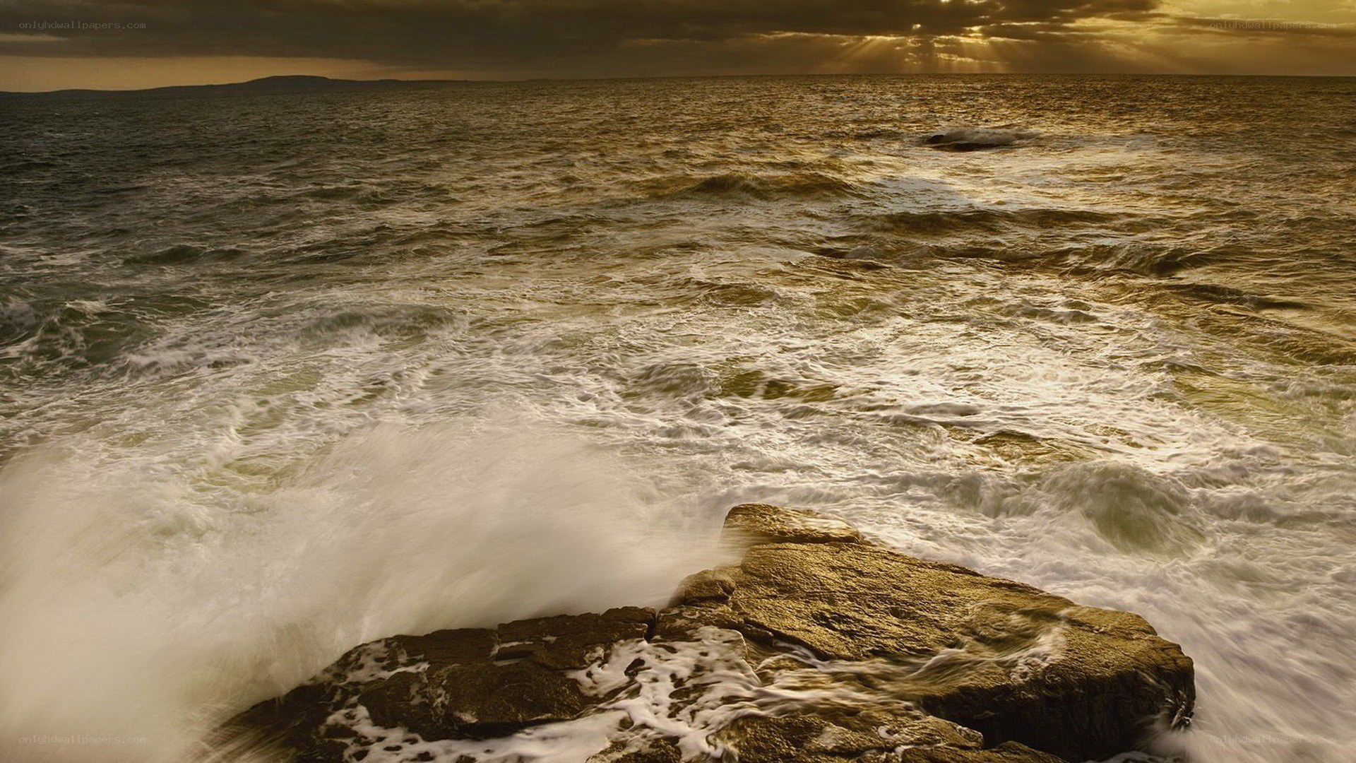 Waves crashing on rocks at sunset