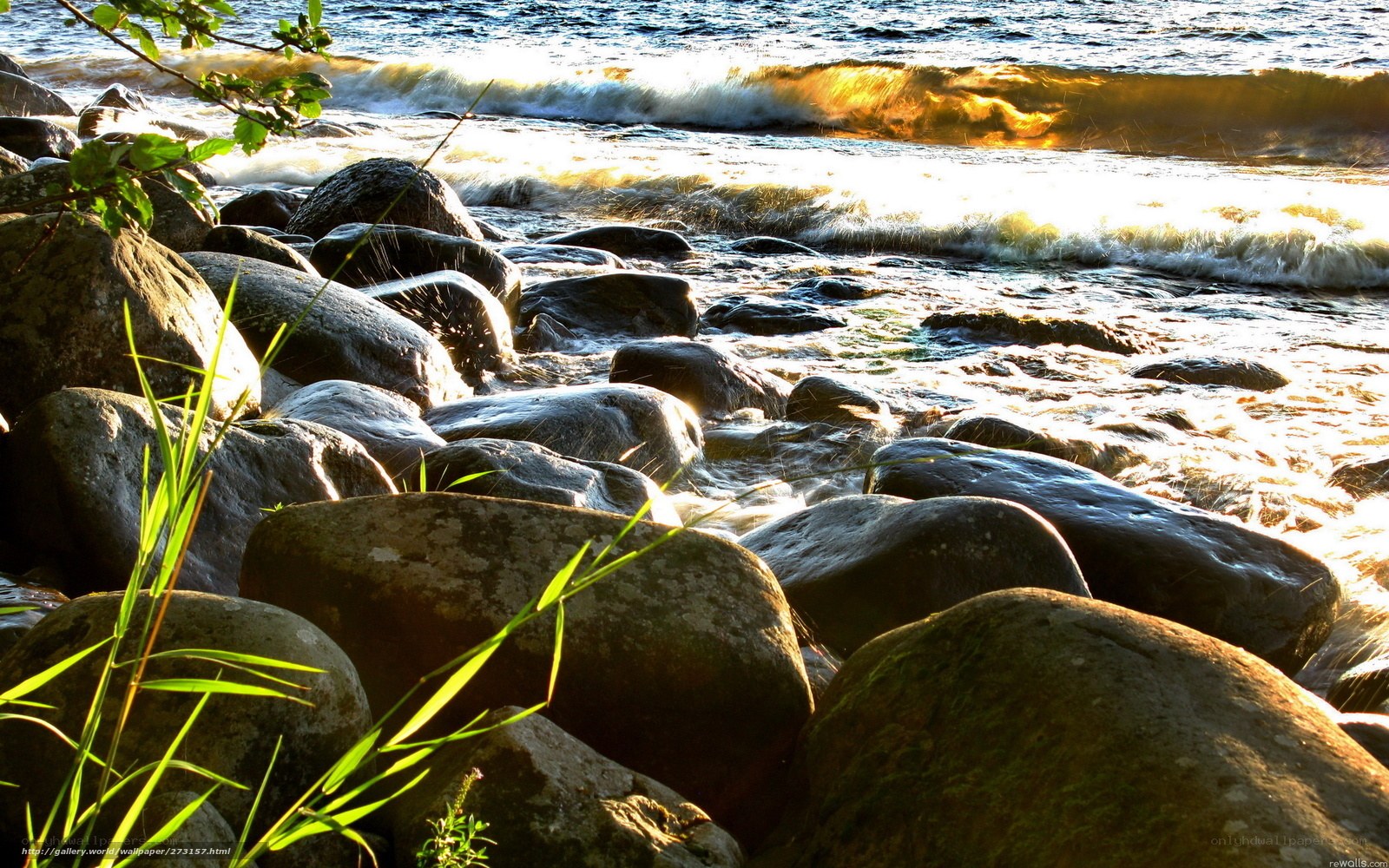 Waves crashing on rocks at sunset