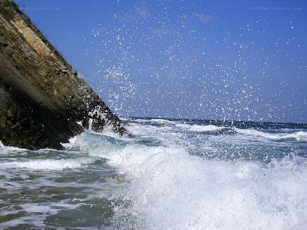 Waves crashing on rocky cliff