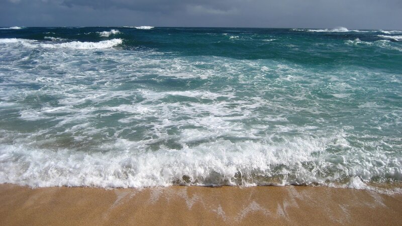 Waves crashing on sandy beach