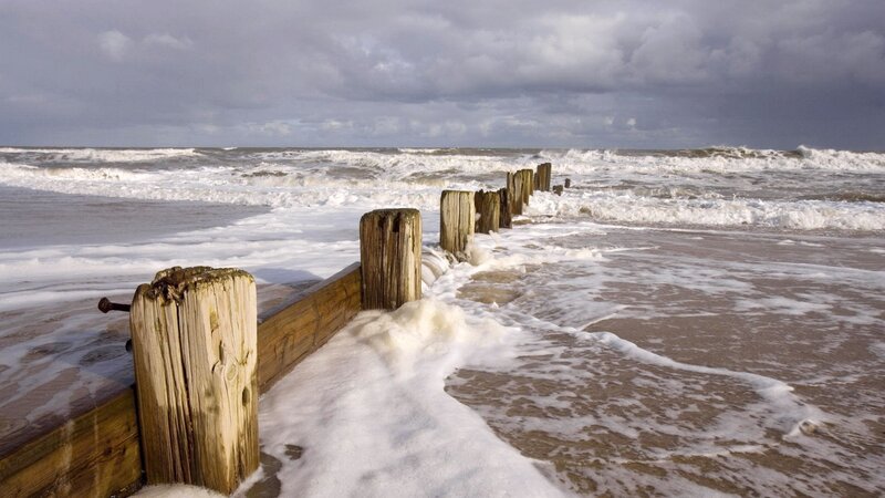 Waves crashing on wooden groynes
