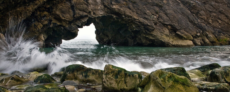 Waves crashing through sea arch