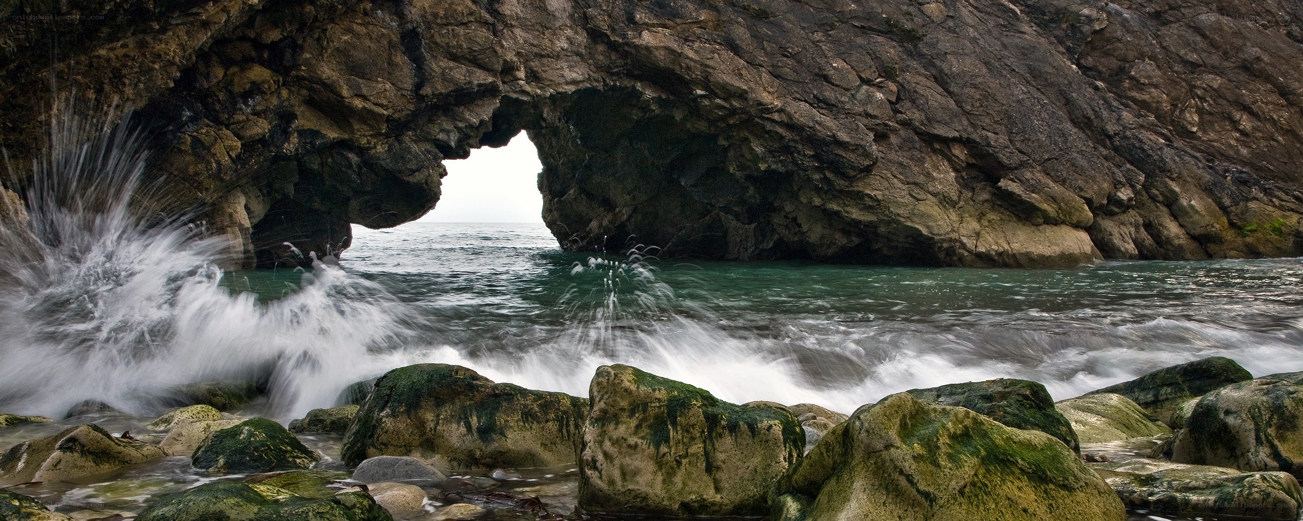 Waves crashing through sea arch