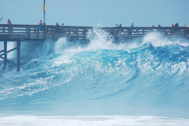 Waves crashing under a pier
