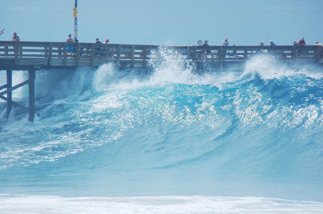 Waves crashing under a pier
