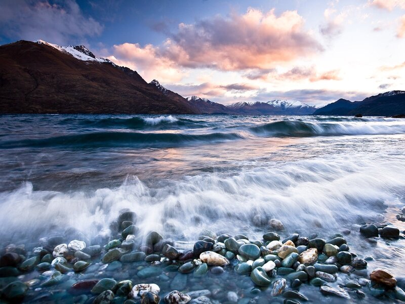 Waves on a pebble beach at sunset
