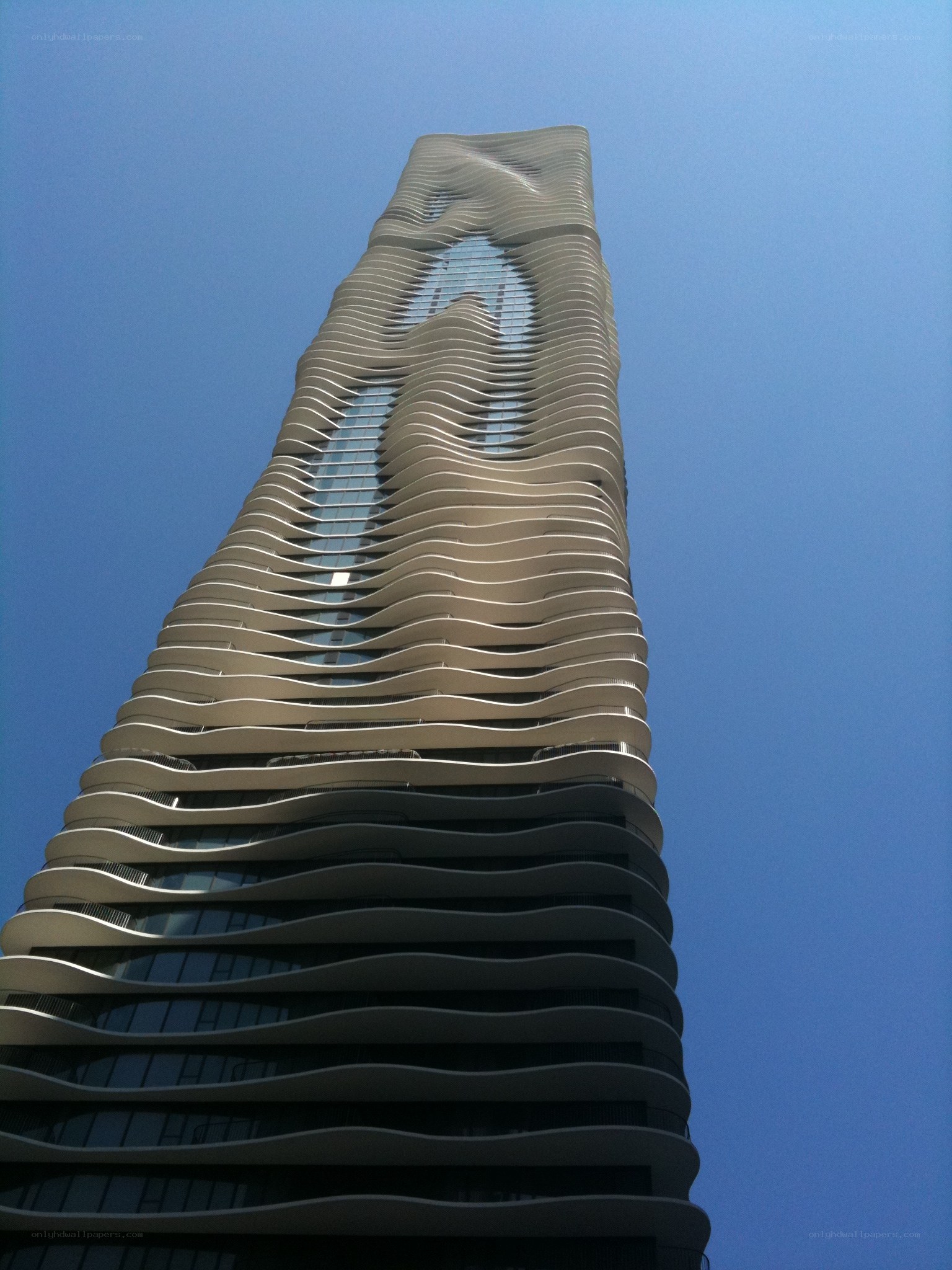 wavy skyscraper against blue sky