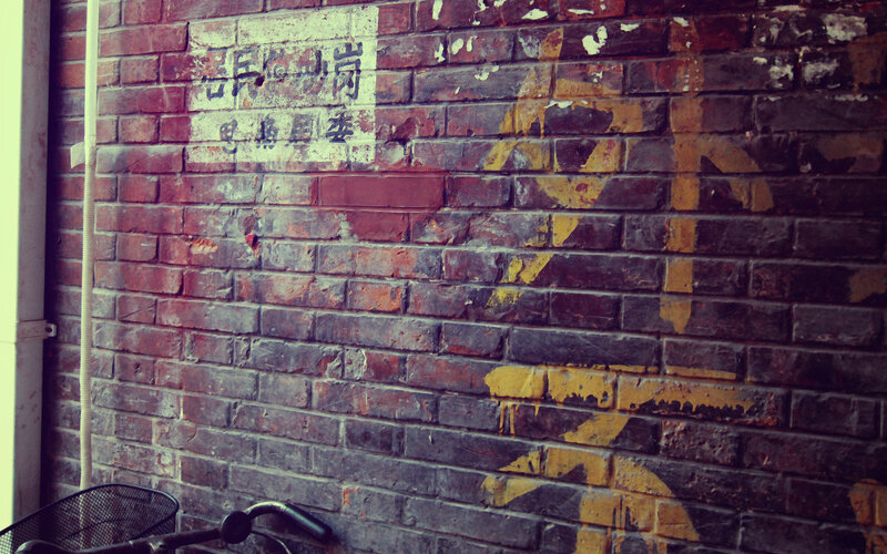 weathered brick wall with faded sign