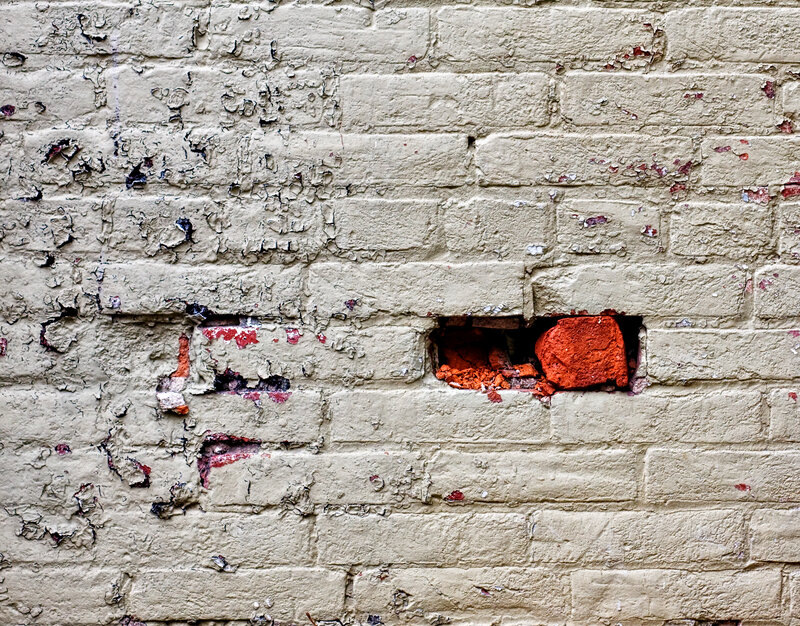 weathered brick wall with holes