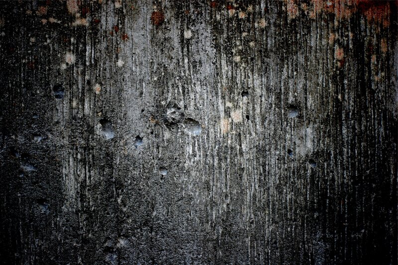 weathered concrete wall with bullet holes