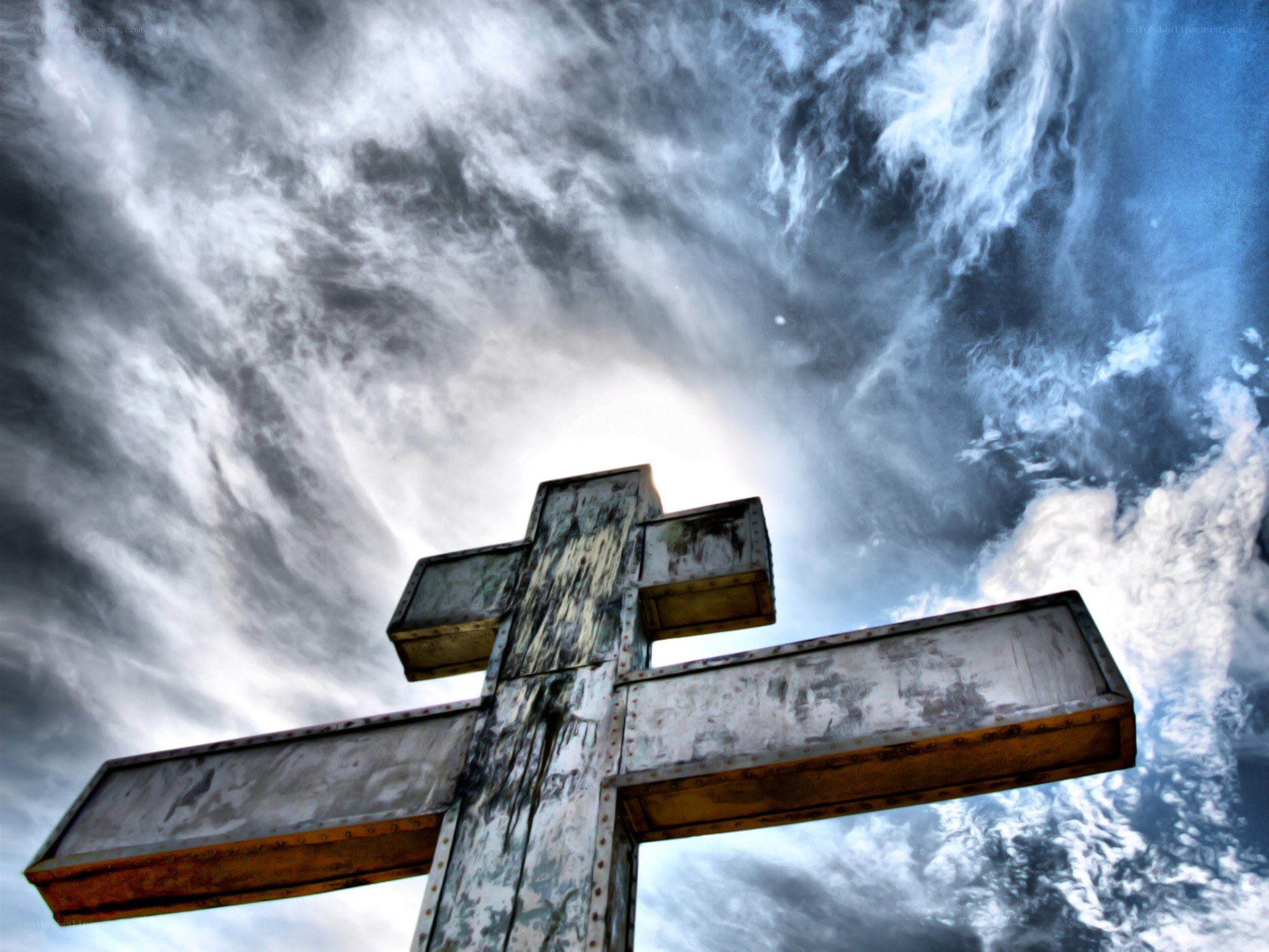 Weathered cross against stormy sky