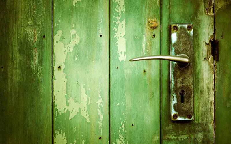 weathered green door with handle