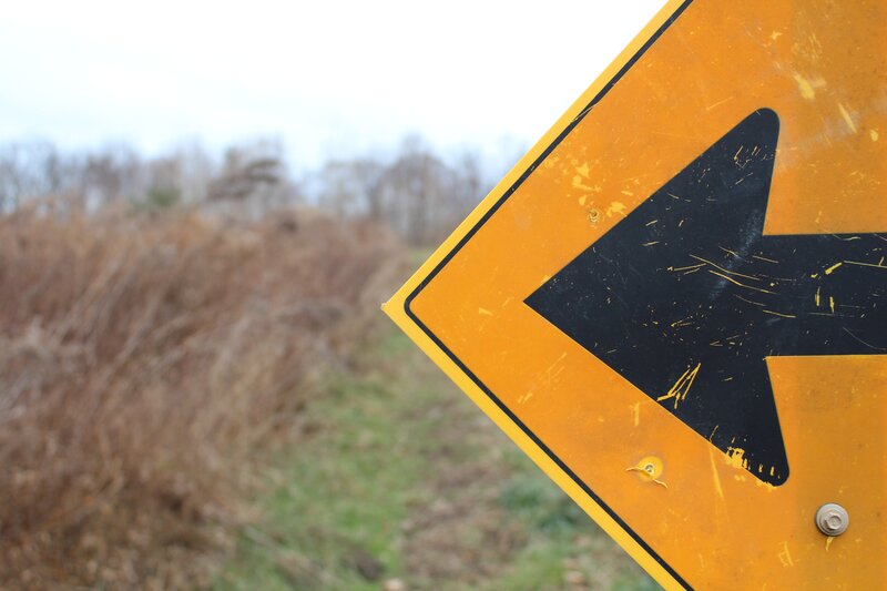 weathered left turn sign