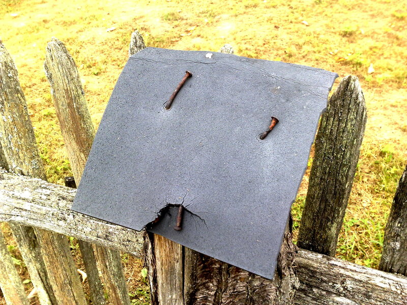 Weathered sign on wooden fence