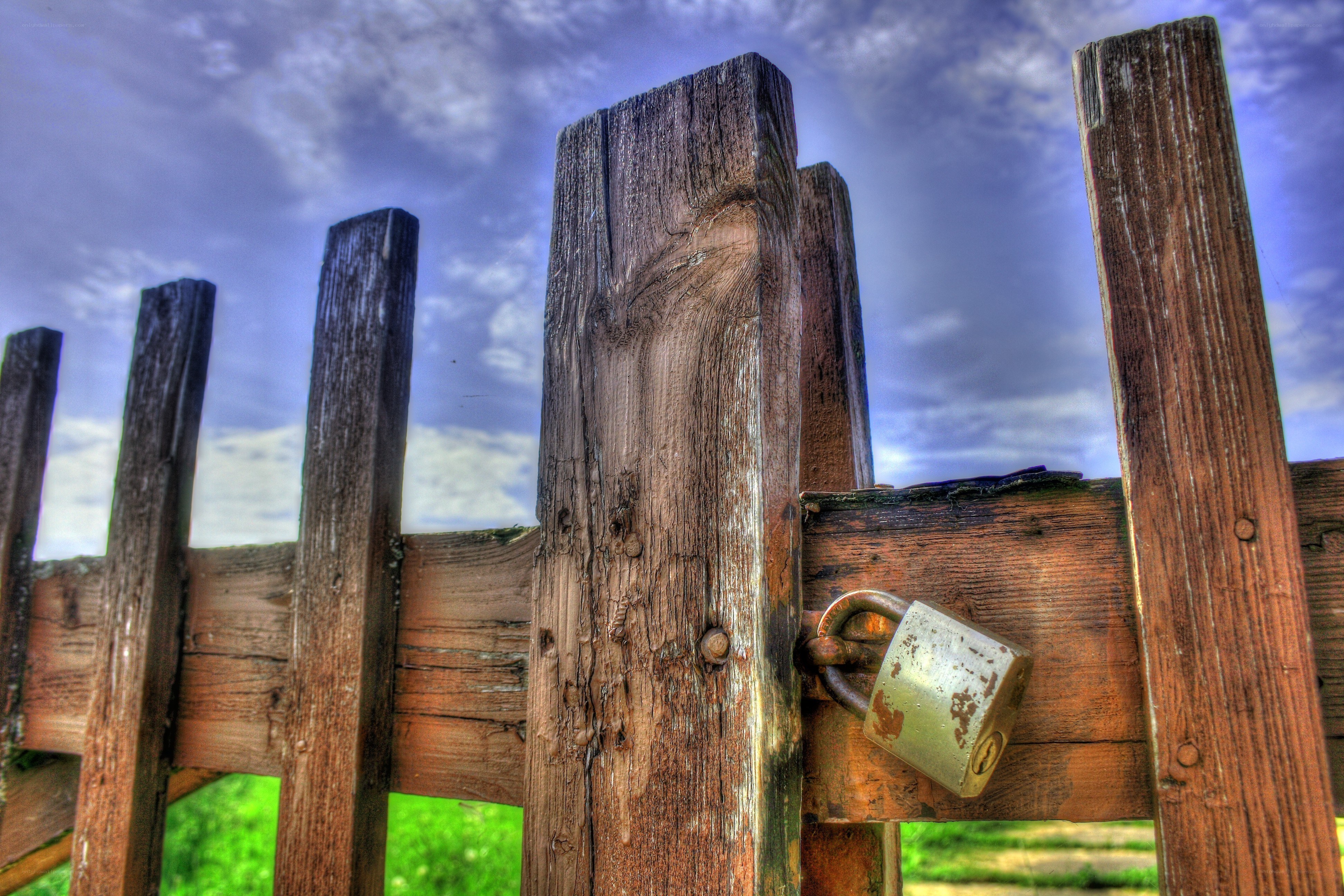 Weathered wooden gate with padlock