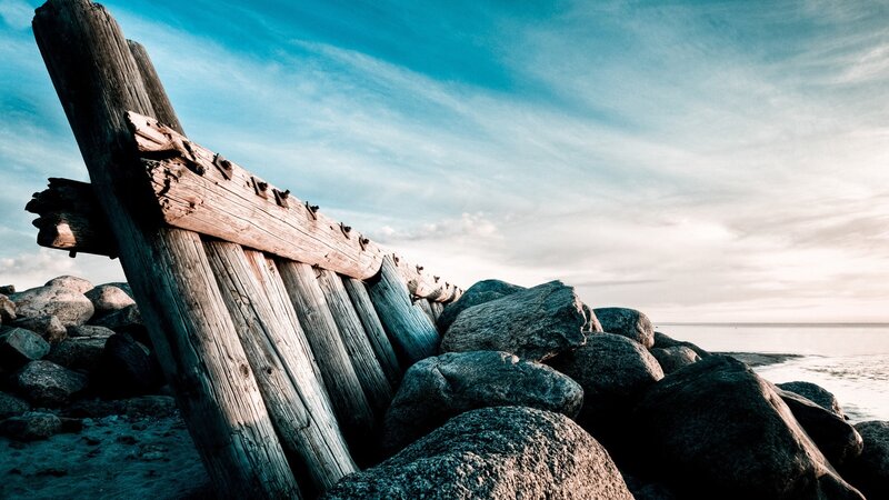 Weathered wooden structure on rocky shore