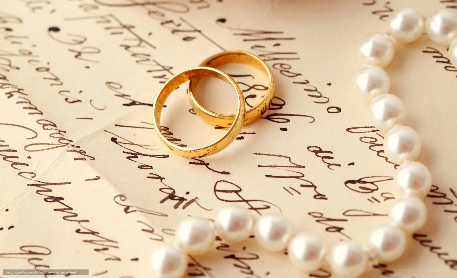 Wedding rings and pearls on letter