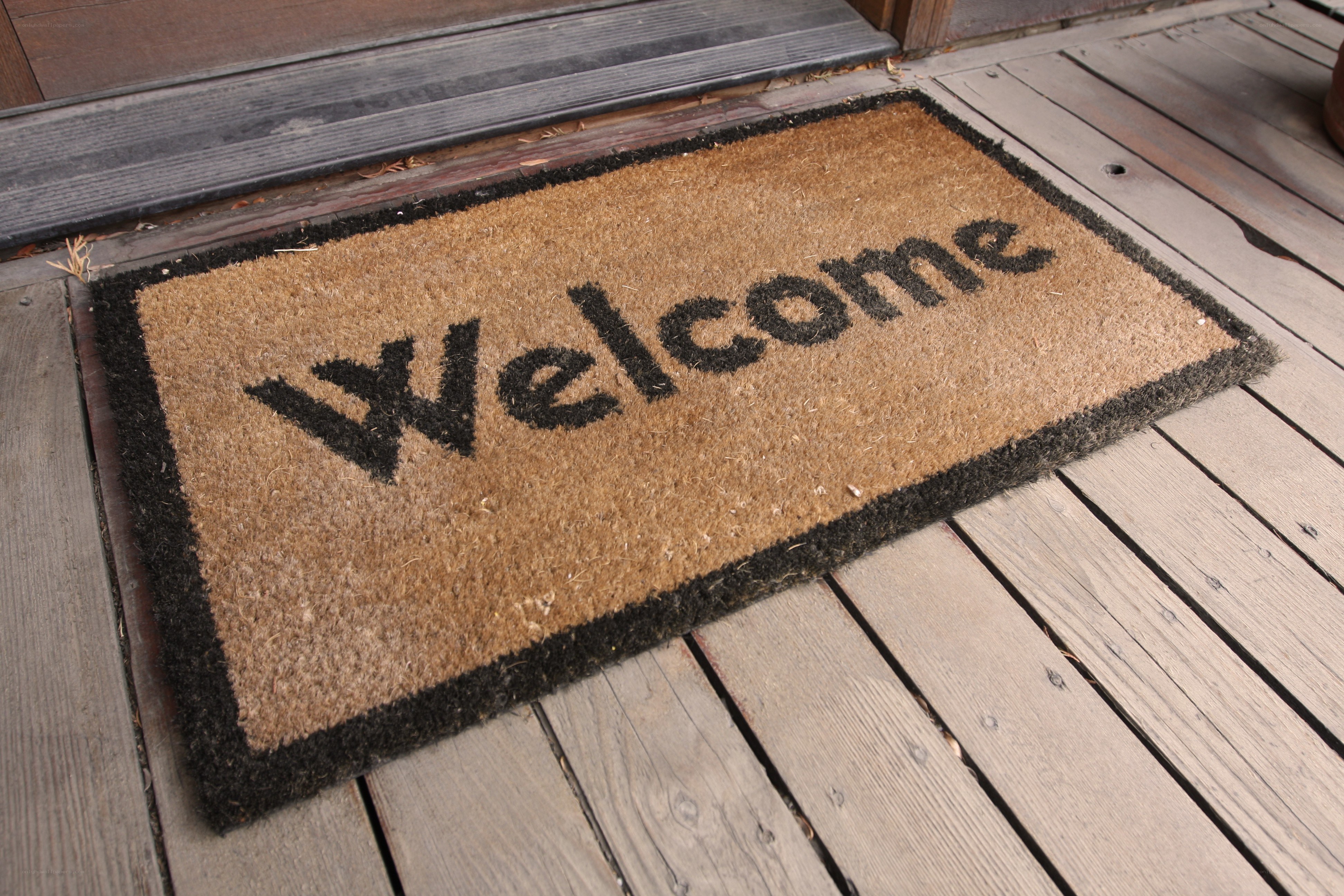 welcome mat on wooden deck