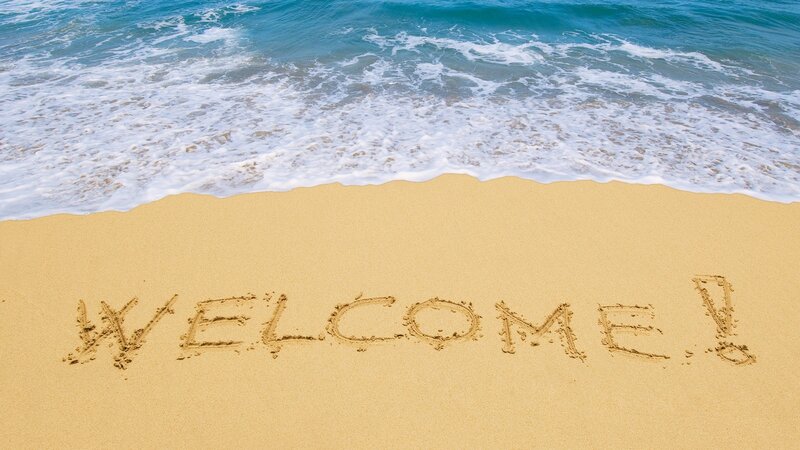 Welcome message on sandy beach