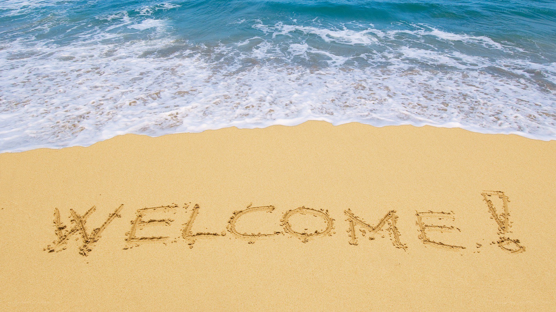 Welcome message on sandy beach