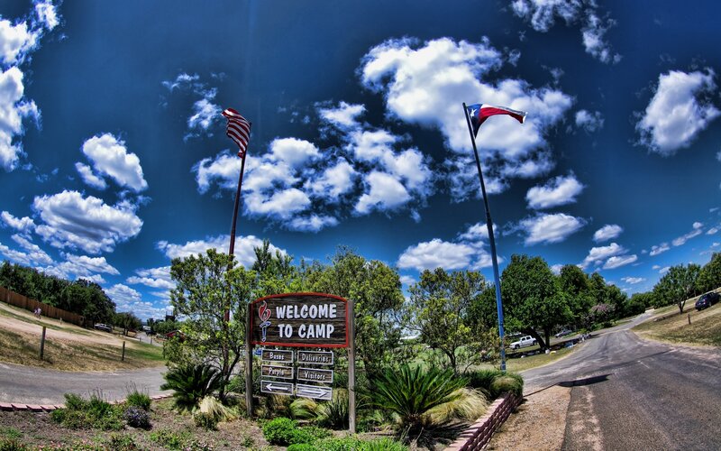 Welcome to Camp sign with flags