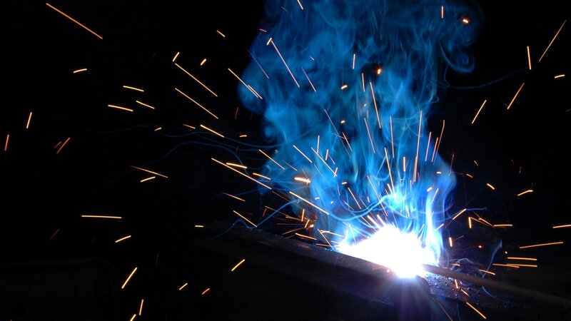 Welding sparks and blue flame
