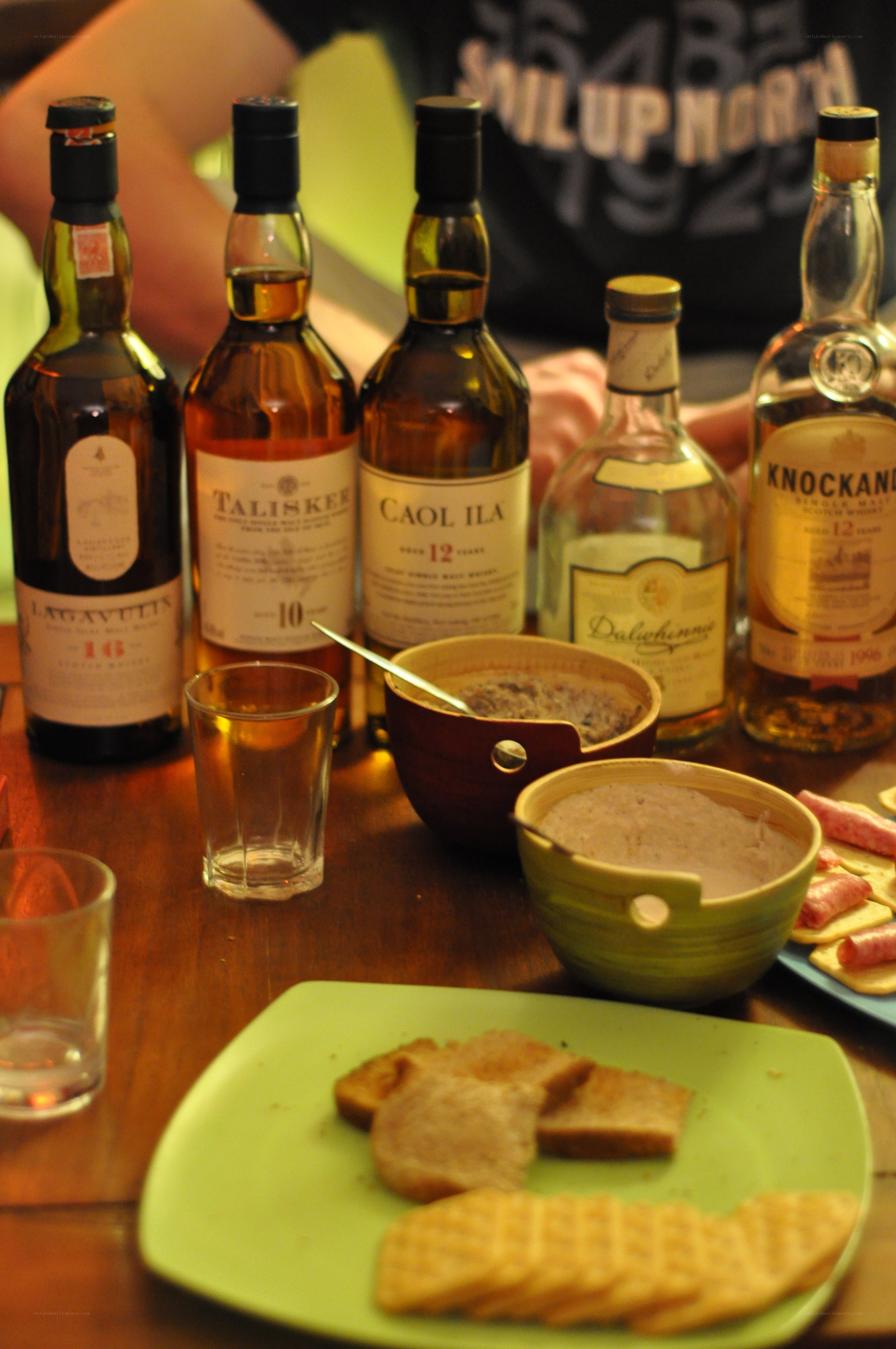 Whiskey bottles and snacks on a table