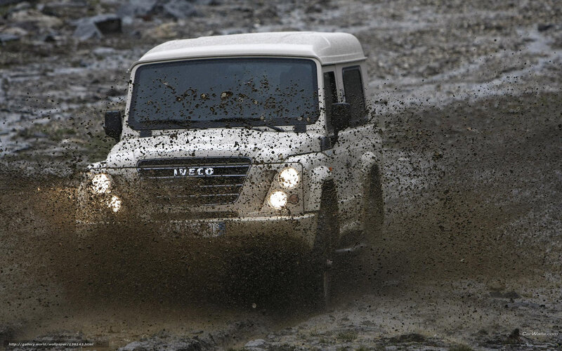 white 4x4 driving through mud
