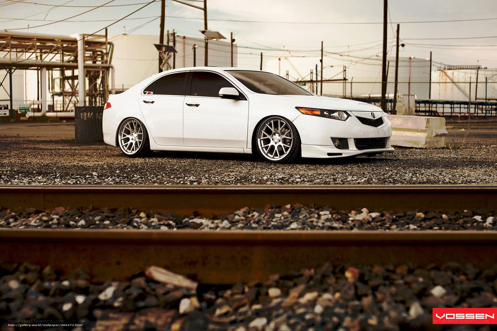 white acura sedan on train tracks