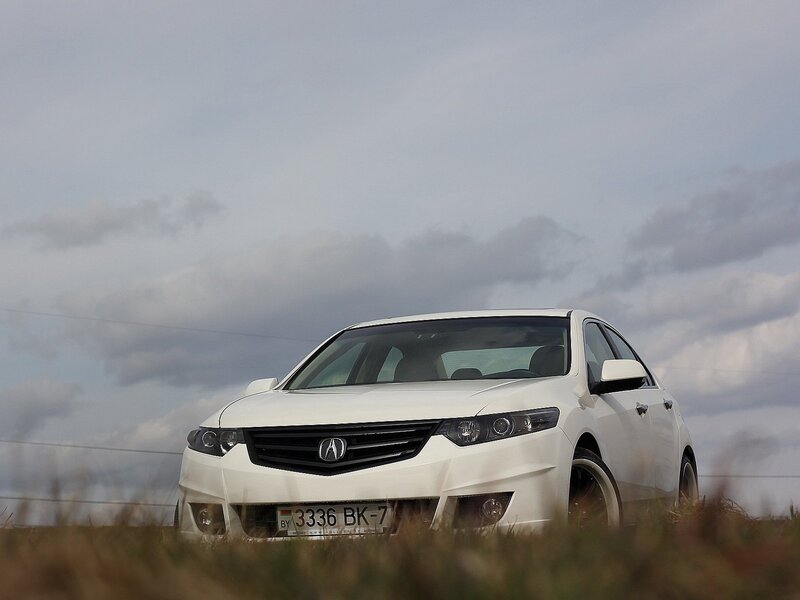 White Acura TL on a grassy field
