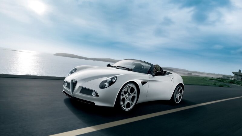White Alfa Romeo driving on coastal road
