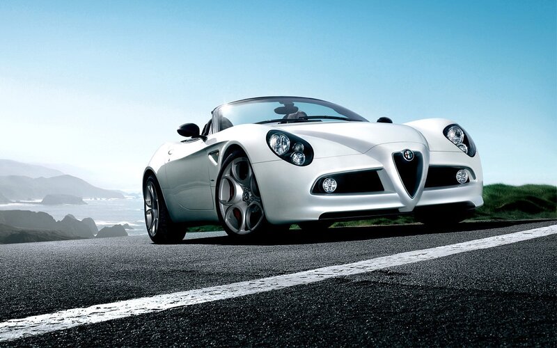 White Alfa Romeo Spider on coastal road