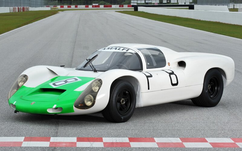 White and green race car on track