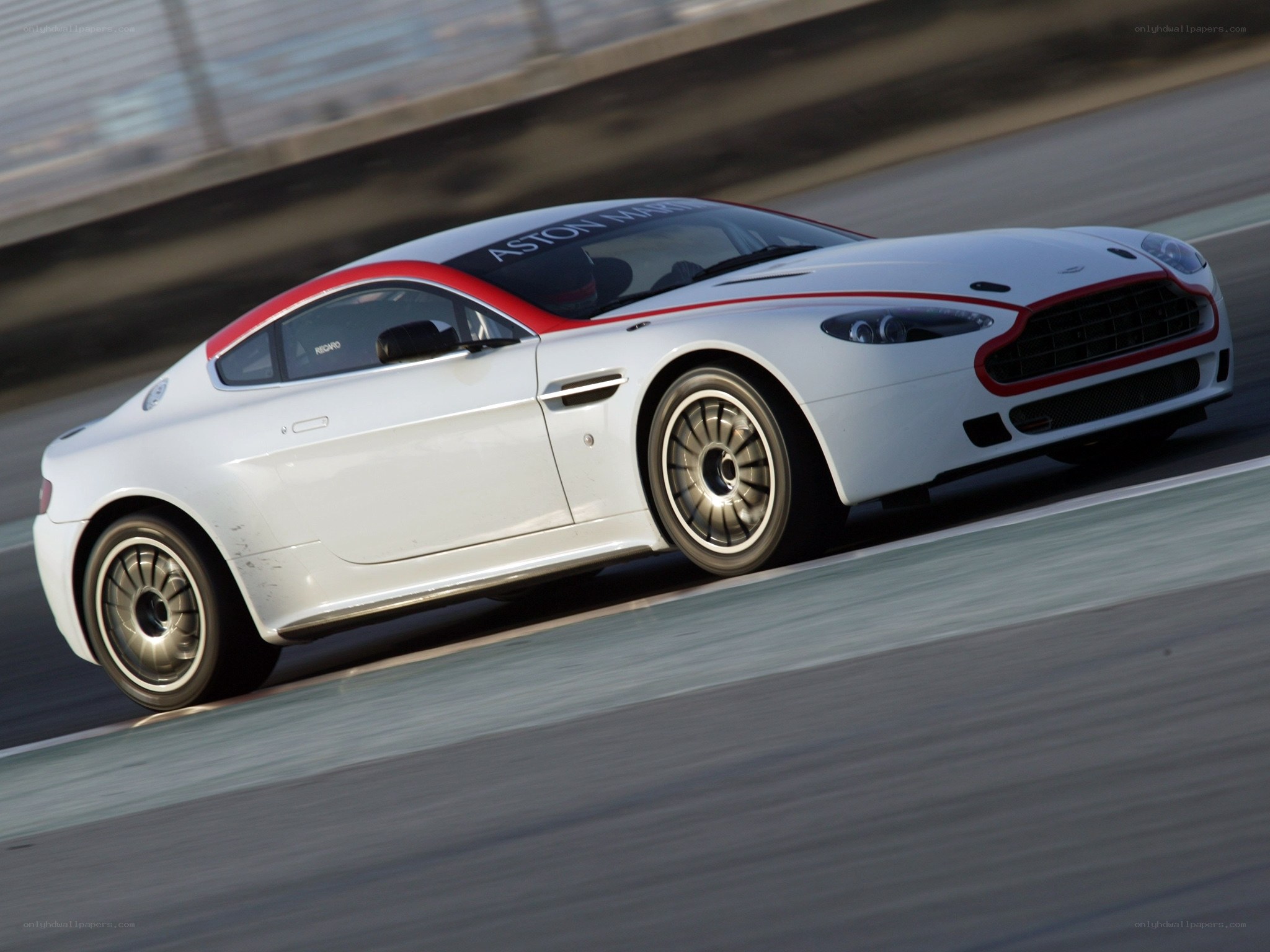 white aston martin on racetrack