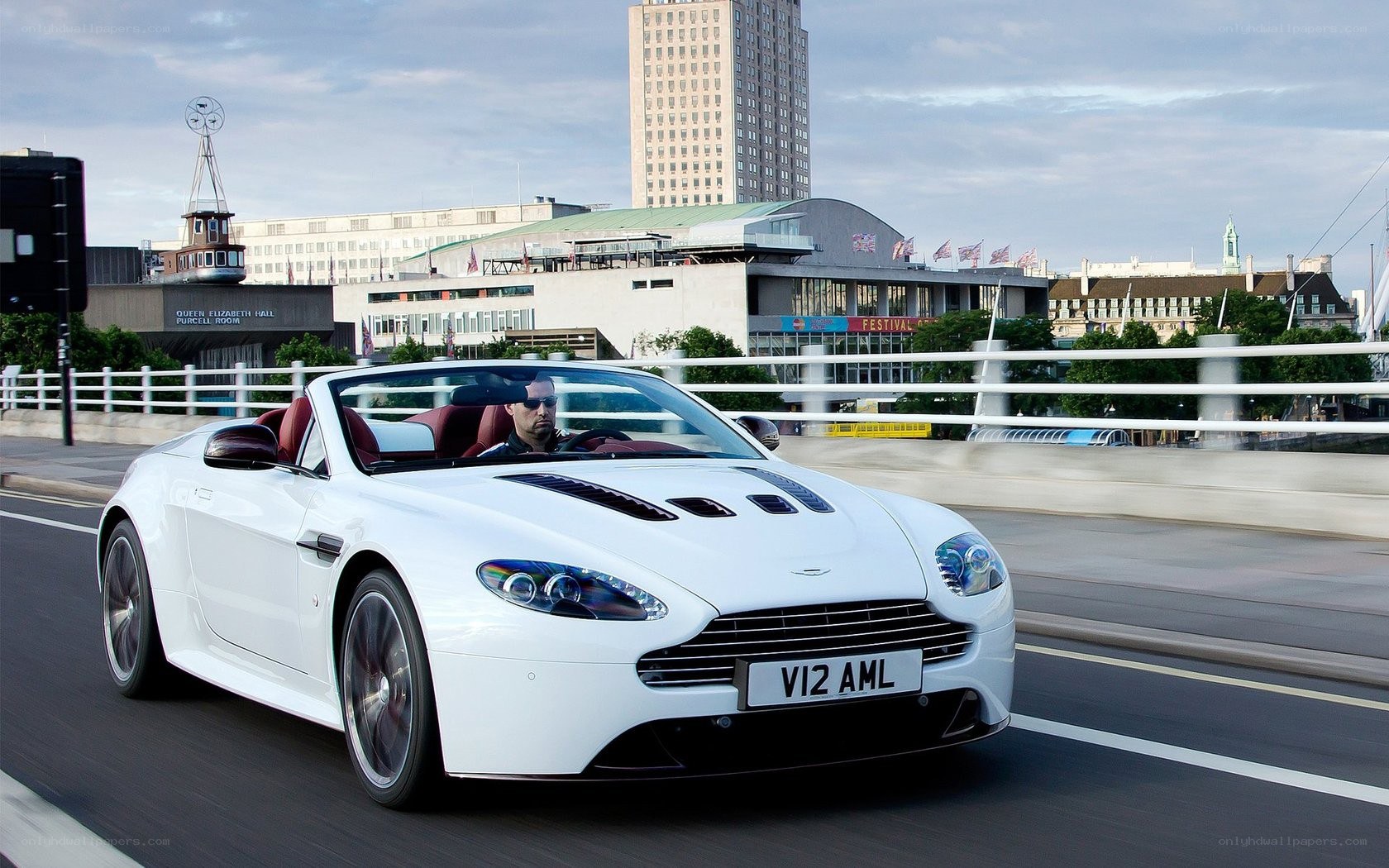 White Aston V12 convertible on bridge