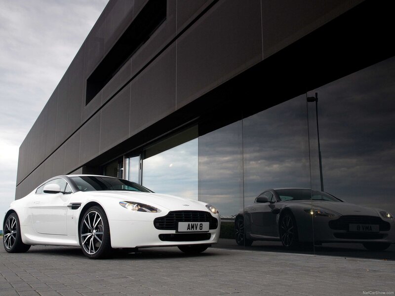 White Aston V8 in front of modern building
