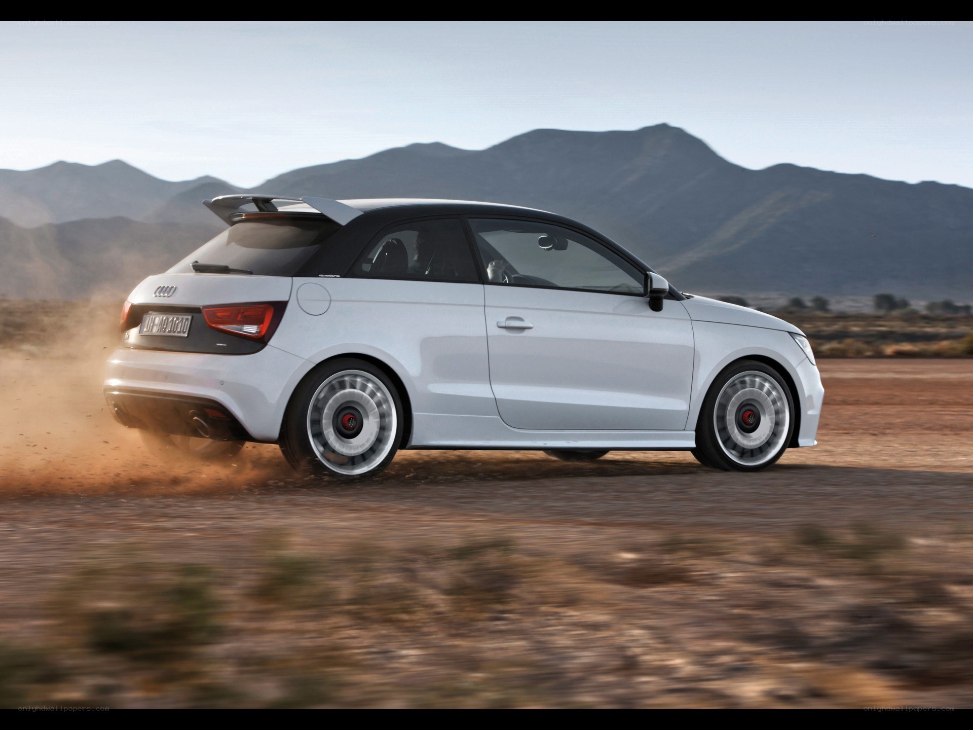 White Audi A1 driving on dirt